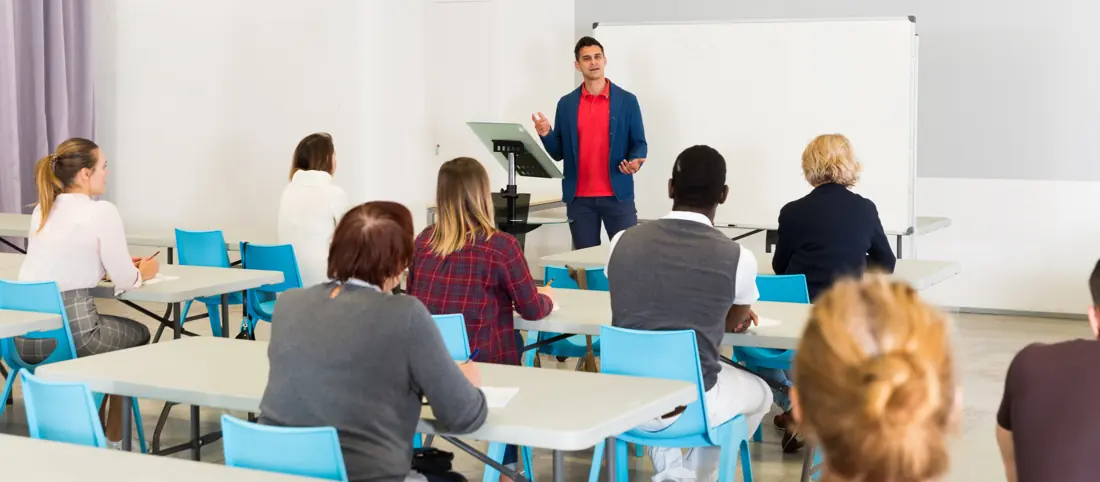 A trainer presenting to a group of adult learners